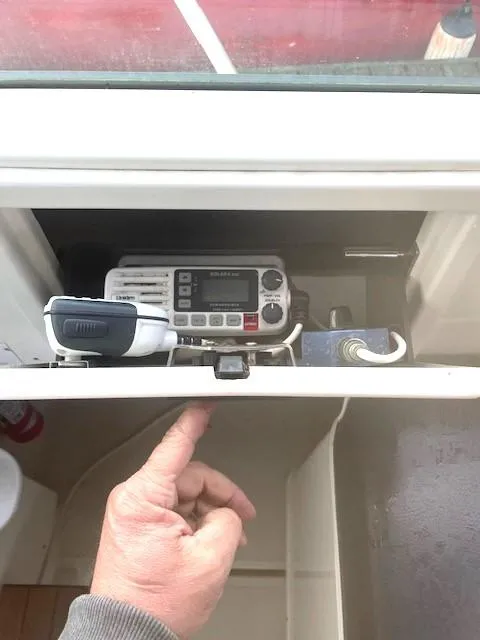 Slide: The Image of 1990 Tiara Yachts 3100 Open radio compartment with hand accessing controls. - 17