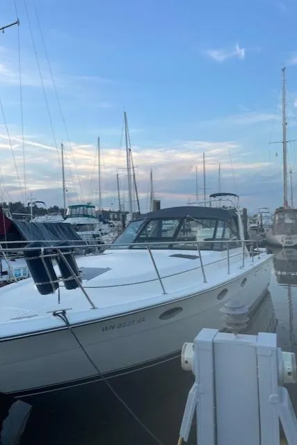 Slide: The Image of 1990 Tiara Yachts 3100 Open docked at marina, surrounded by other boats. - 2