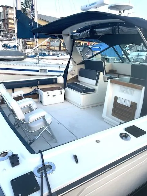Slide: The Image of 1990 Tiara Yachts 3100 Open with spacious deck and seating area, docked at marina. - 22