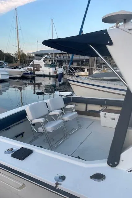 Slide: The Image of 1990 Tiara Yachts 3100 Open docked, featuring spacious seating and sleek design. - 23