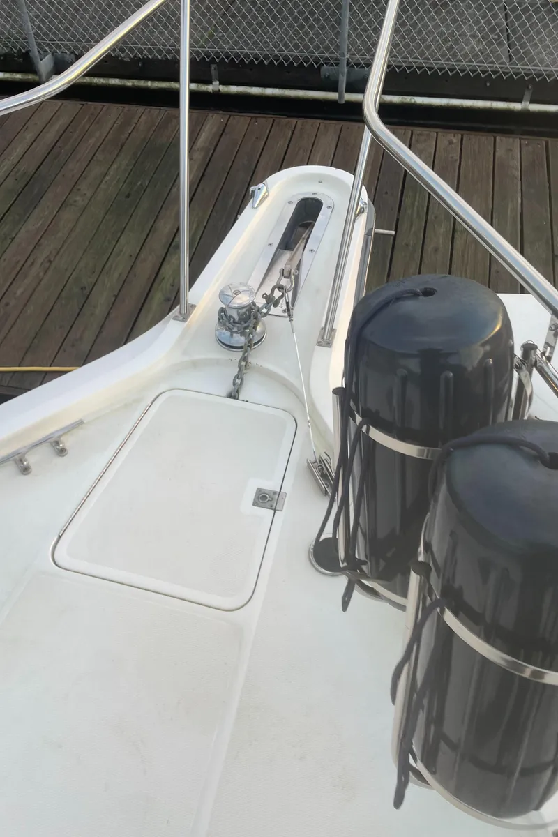 Slide: The Image of 1990 Tiara Yachts 3100 Open deck with anchor and fenders at dock. - 25