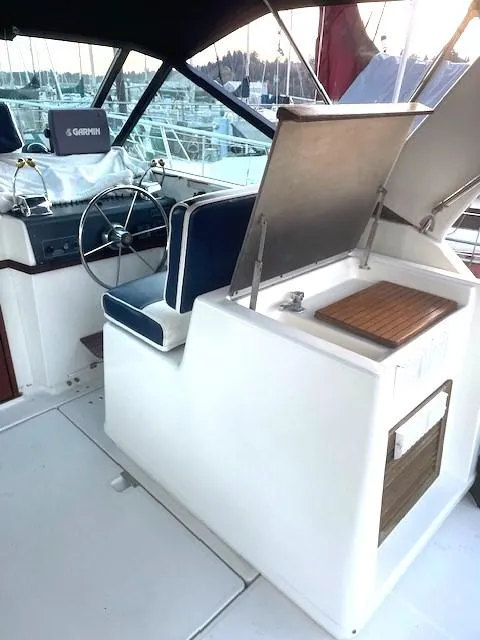 Slide: The Image of 1990 Tiara Yachts 3100 Open cockpit with steering wheel and seating, docked at marina. - 4