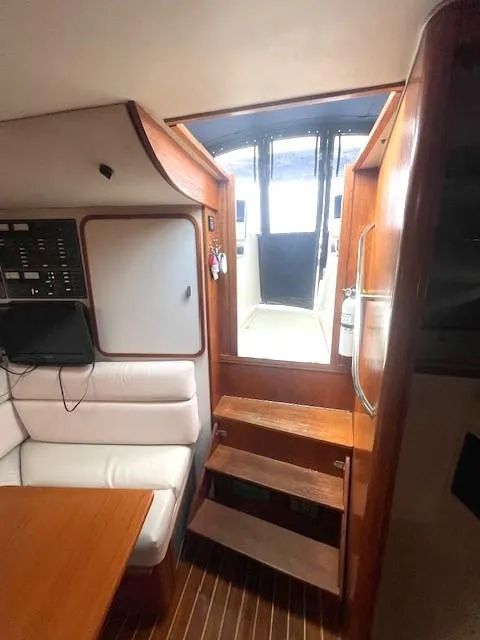 Slide: The Image of Interior of 1990 Tiara Yachts 3100 Open, featuring wooden steps and seating area. - 6