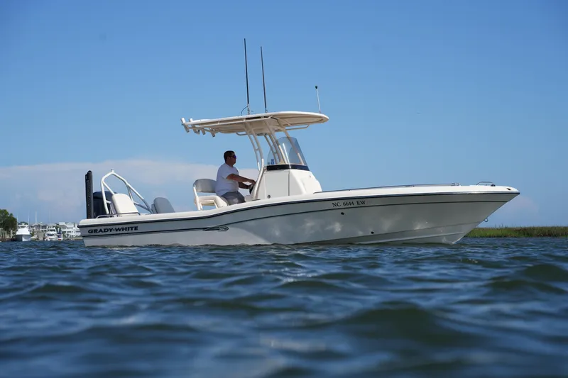 Slide: The Image of 2016 Grady-White 251 Coastal Explorer boat cruising on calm water under clear blue sky. - 11