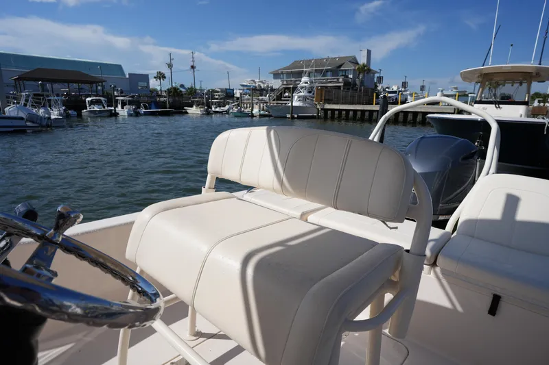 Slide: The Image of 2016 Grady-White 251 Coastal Explorer boat interior at marina, featuring helm seat and steering wheel. - 17