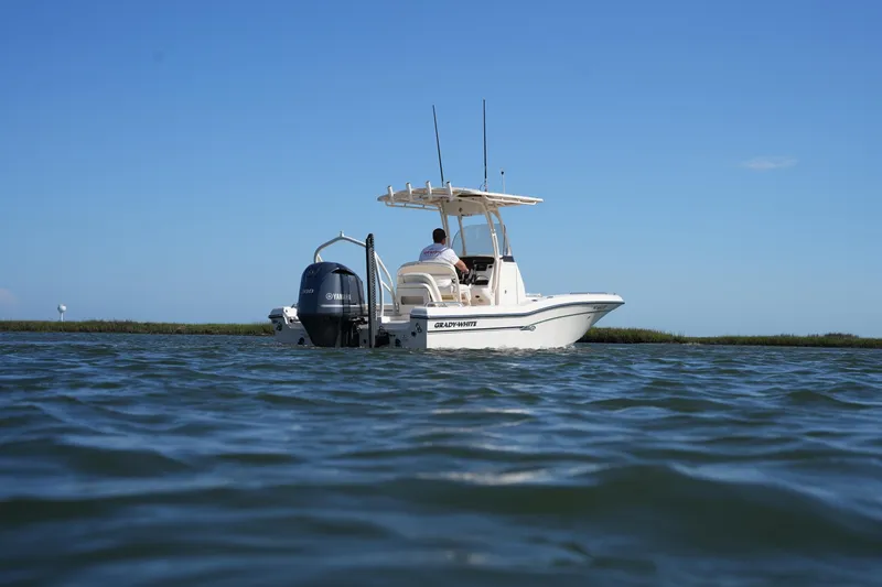 Slide: The Image of 2016 Grady-White 251 Coastal Explorer boat on calm water under clear blue sky. - 4