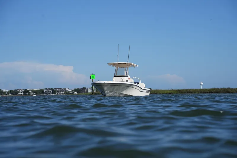 Slide: The Image of 2016 Grady-White 251 Coastal Explorer boat on calm water under clear blue sky. - 8