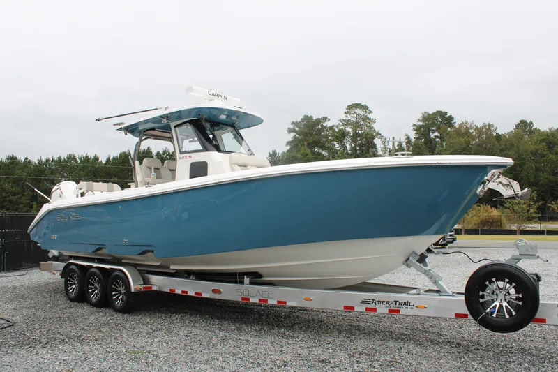 Slide: The Image of 2024 Solace 32 CS boat on trailer, blue hull, parked outdoors. - 0