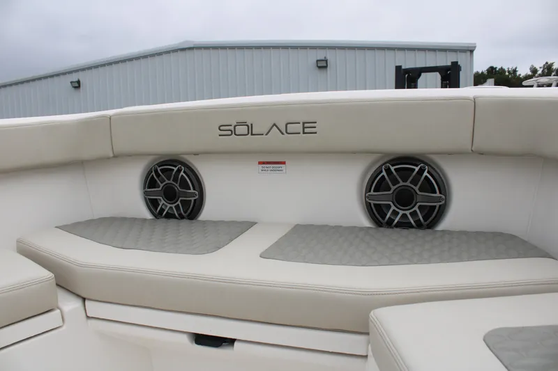 Slide: The Image of 2024 Solace 32 CS boat interior with cushioned seating and built-in speakers. - 11