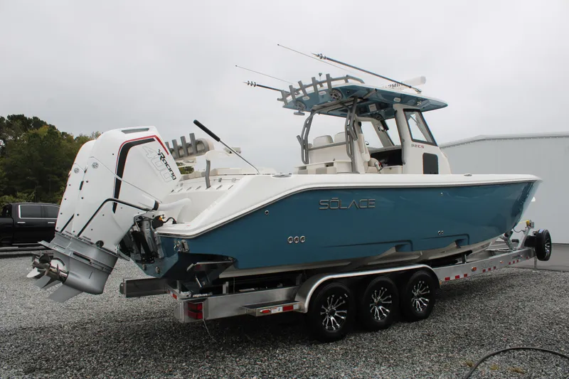 Slide: The Image of 2024 Solace 32 CS boat on trailer, featuring dual engines and sleek blue design. - 2