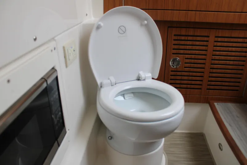 Slide: The Image of 2024 Solace 32 CS boat interior with modern toilet and wooden cabinetry. - 20