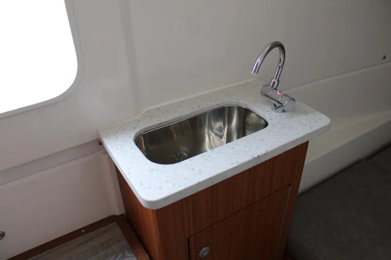 Slide: The Image of 2024 Solace 32 CS boat interior with a sleek sink and faucet setup. - 22