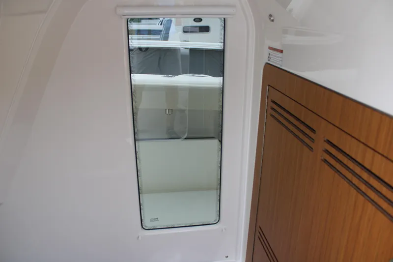 Slide: The Image of Interior view of 2024 Solace 32 CS boat, featuring sleek design and wooden cabinetry. - 23