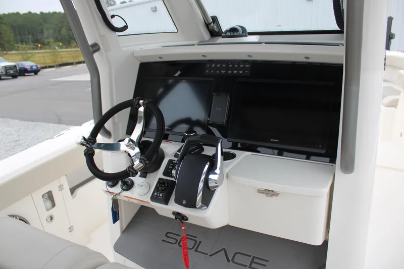 Slide: The Image of 2024 Solace 32 CS boat dashboard with steering wheel and control panel. - 25