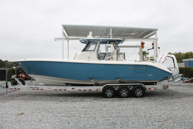 Slide: The Image of 2024 Solace 32 CS boat on trailer, blue hull, parked outdoors. - 3