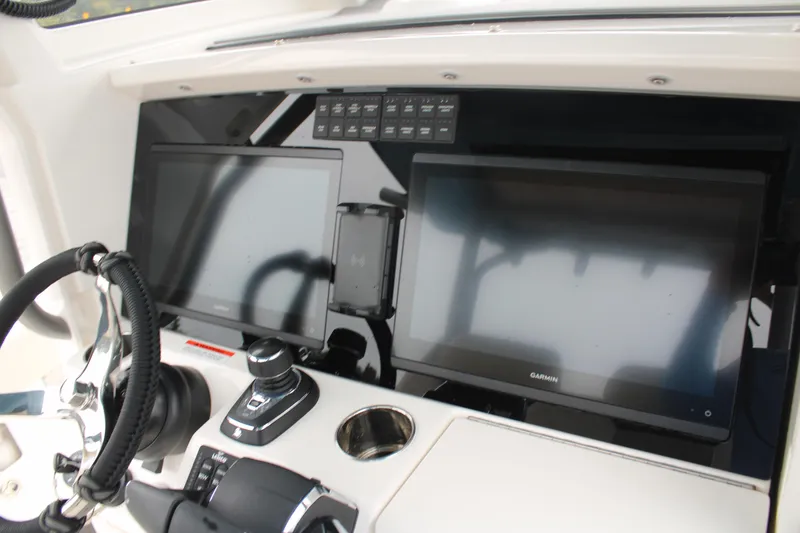 Slide: The Image of 2024 Solace 32 CS boat dashboard with dual Garmin displays and steering controls. - 30