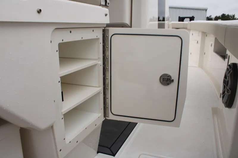 Slide: The Image of 2024 Solace 32 CS boat storage compartment with open door and shelves. - 38