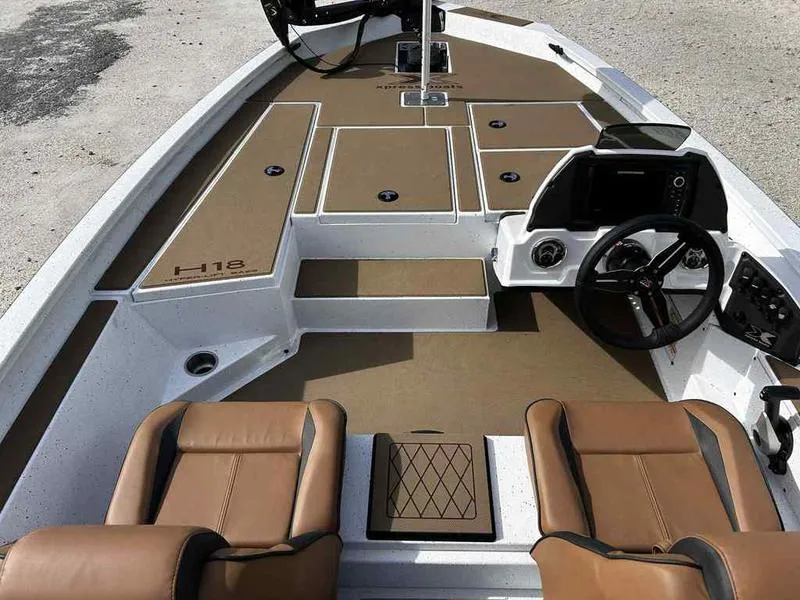 Slide: The Image of 2025 Xpress H18B boat interior with brown seating and modern dashboard. - 14
