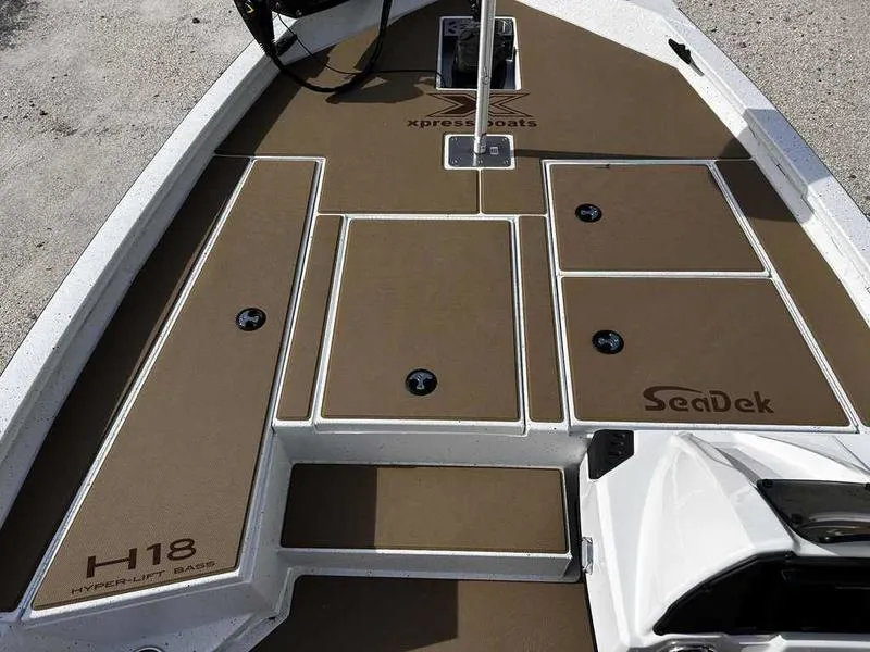 Slide: The Image of 2025 Xpress H18B boat deck with SeaDek flooring, showcasing storage compartments. - 19