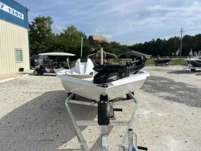 Slide: The Image of 2025 Xpress H18B boat on trailer, featuring a Minn Kota trolling motor, parked outdoors. - 4