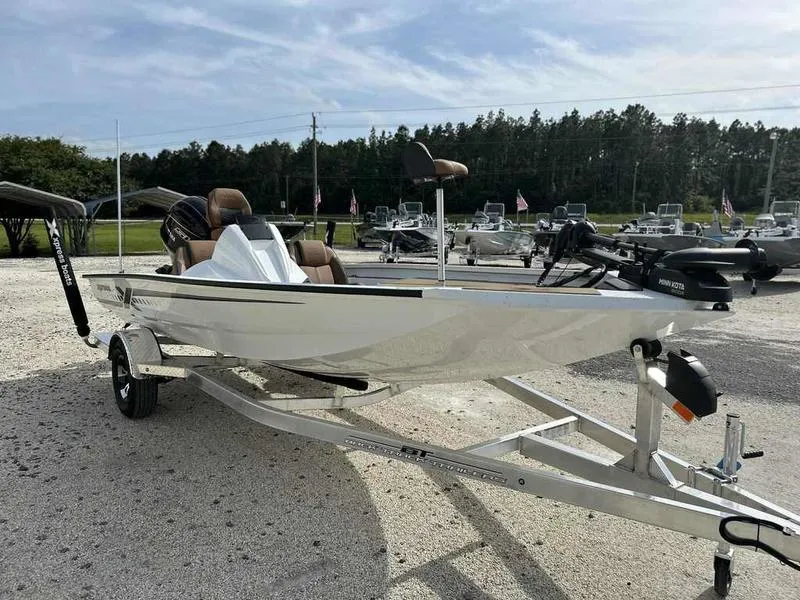 Slide: The Image of 2025 Xpress H18B boat on trailer, parked outdoors with other boats in the background. - 5