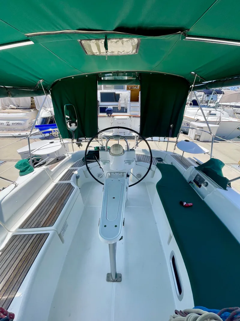 Slide: The Image of Cockpit of 2004 Beneteau 423 sailboat with green canopy and steering wheel. - 10
