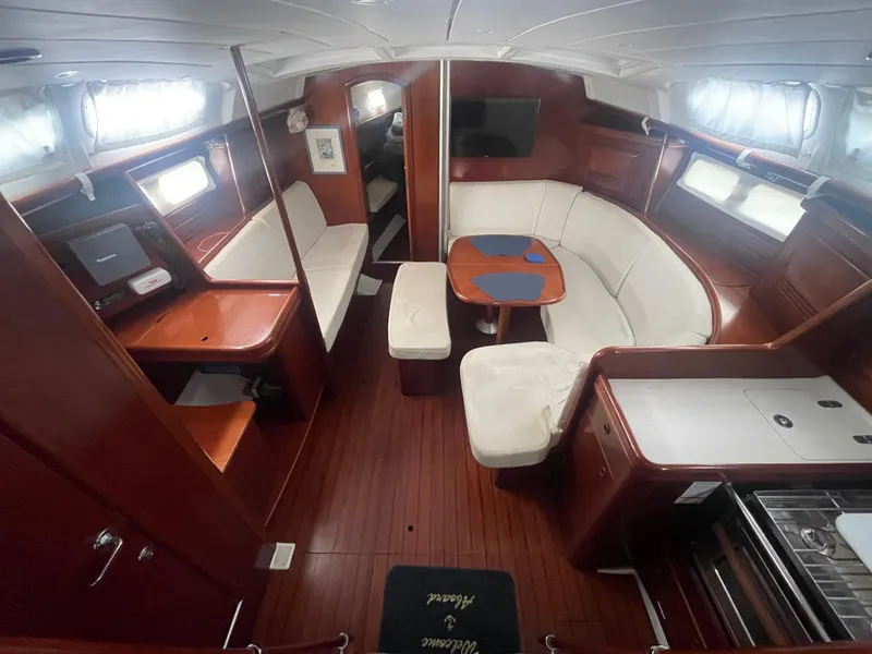 Slide: The Image of Interior of 2004 Beneteau 423 yacht with elegant wood finish and cozy seating area. - 14