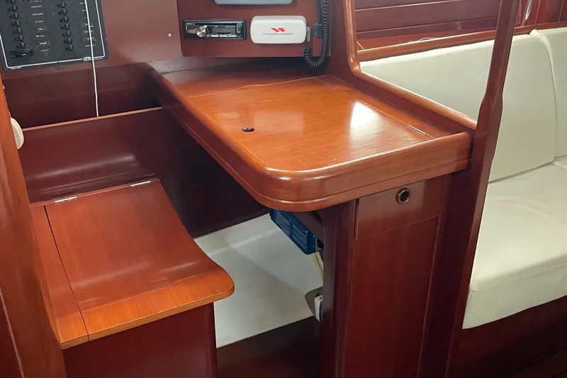 Slide: The Image of Interior of 2004 Beneteau 423 sailboat with wooden navigation desk and seating area. - 18