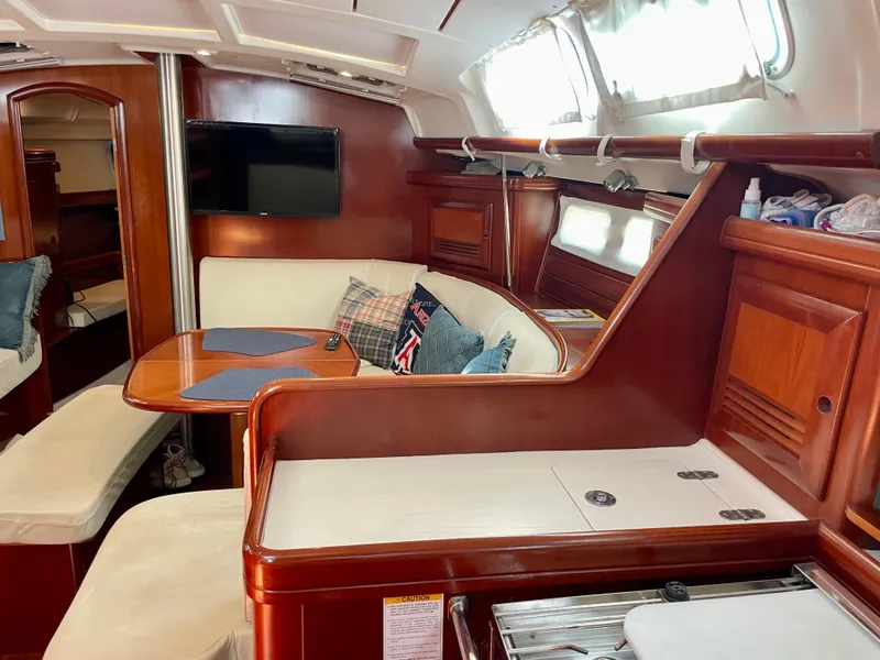 Slide: The Image of Interior of 2004 Beneteau 423 sailboat with cozy seating and wooden finishes. - 3
