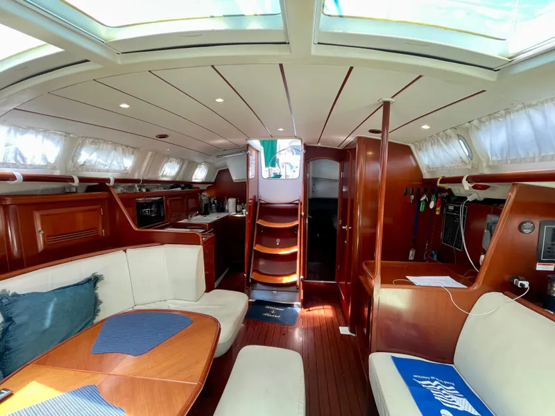 Slide: The Image of Interior of 2004 Beneteau 423 sailboat with elegant wood finish and spacious seating. - 6
