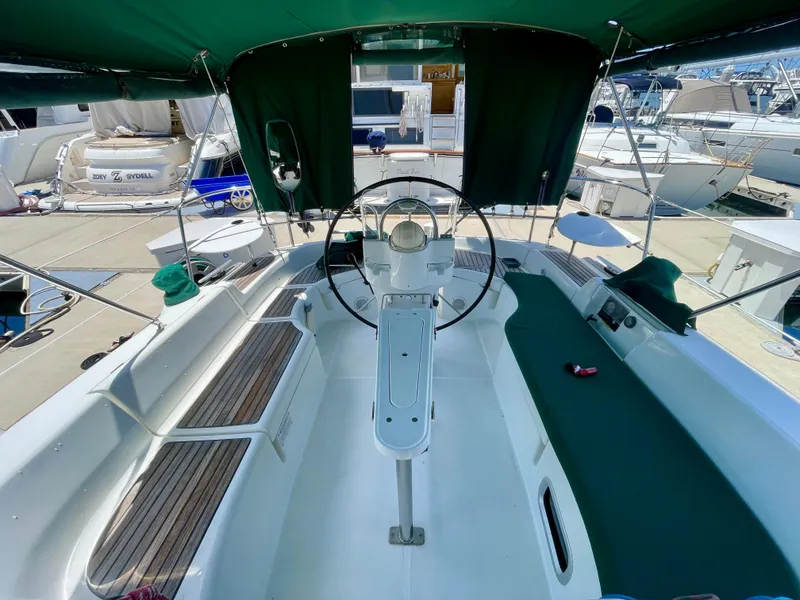 Slide: The Image of Cockpit of a 2004 Beneteau 423 sailboat with green canopy and steering wheel. - 9