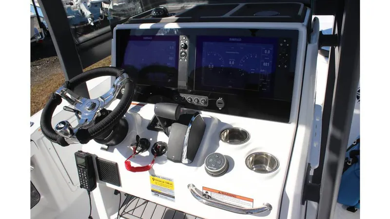Slide: The Image of 2025 Crevalle 26 HCO boat dashboard with dual screens and steering wheel. - 19