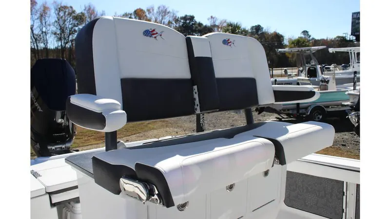 Slide: The Image of 2025 Crevalle 26 HCO boat seating, featuring dual cushioned seats with armrests, outdoors. - 20