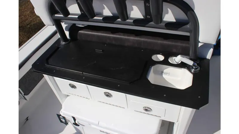 Slide: The Image of 2025 Crevalle 26 HCO boat console with sink, storage drawers, and rod holders. - 23