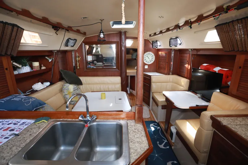Slide: The Image of Interior of a 1988 Catalina 36 sailboat with cozy seating and kitchen area. - 16