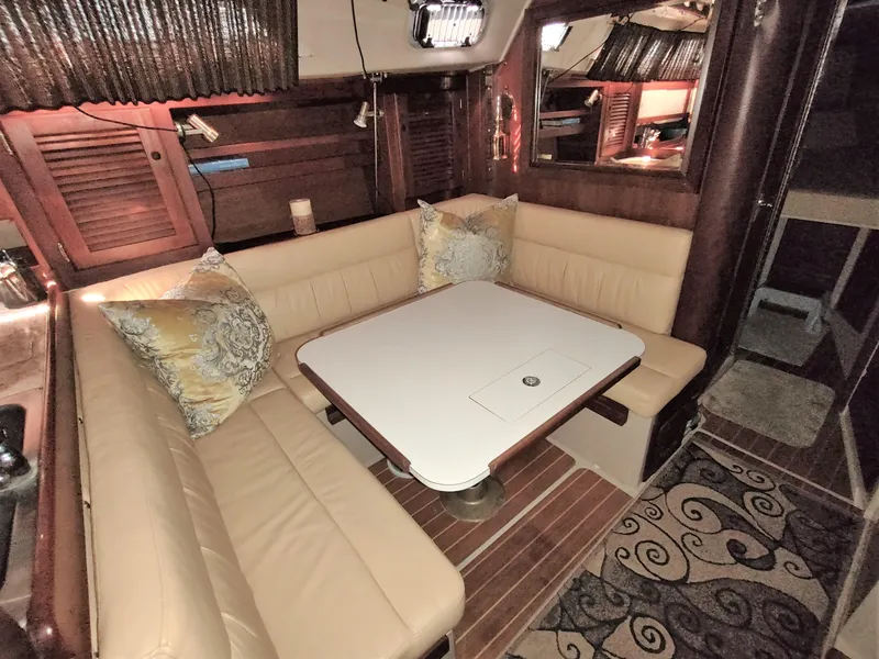 Slide: The Image of Cozy interior of a 1988 Catalina 36 sailboat with a dining area and cushioned seating. - 17