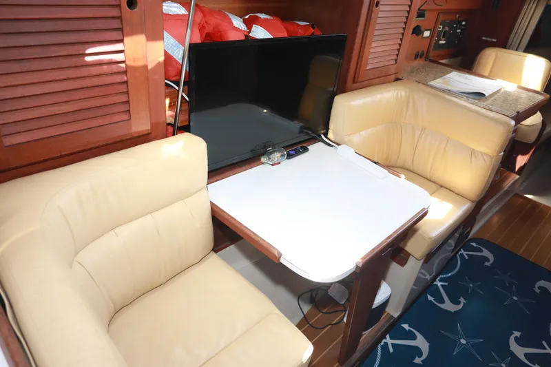 Slide: The Image of Interior of 1988 Catalina 36 yacht with beige seating, table, and TV. - 20