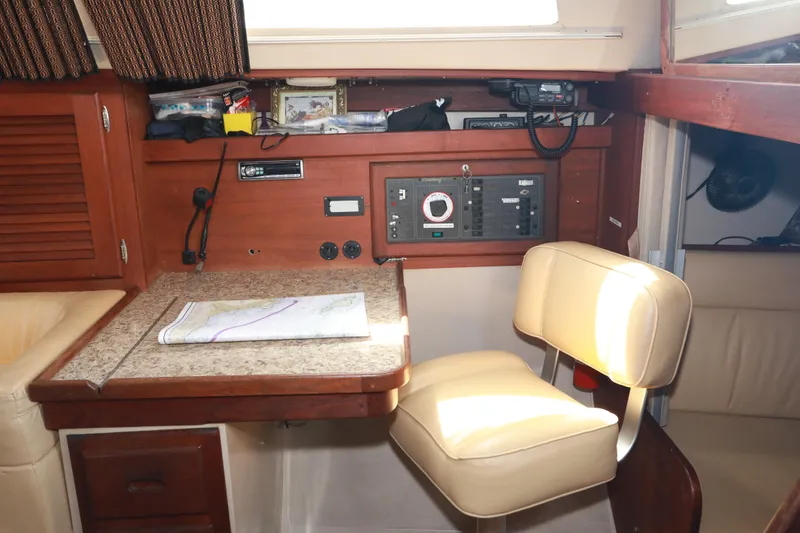 Slide: The Image of Navigation station inside a 1988 Catalina 36 sailboat with control panel and seating. - 21