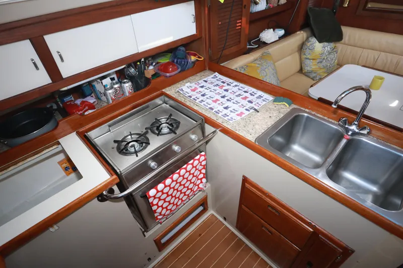 Slide: The Image of Interior of 1988 Catalina 36 yacht kitchen with stove, sink, and seating area. - 29