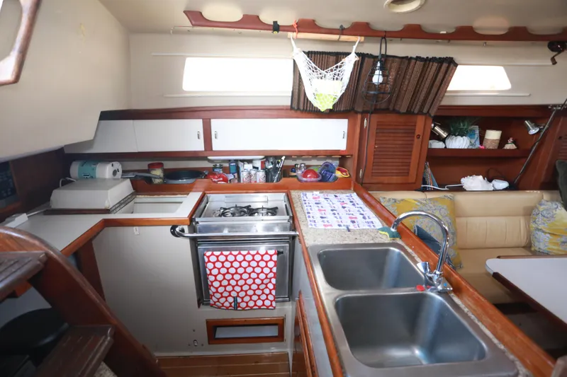 Slide: The Image of Interior of 1988 Catalina 36 sailboat kitchen with stove, sink, and storage cabinets. - 32