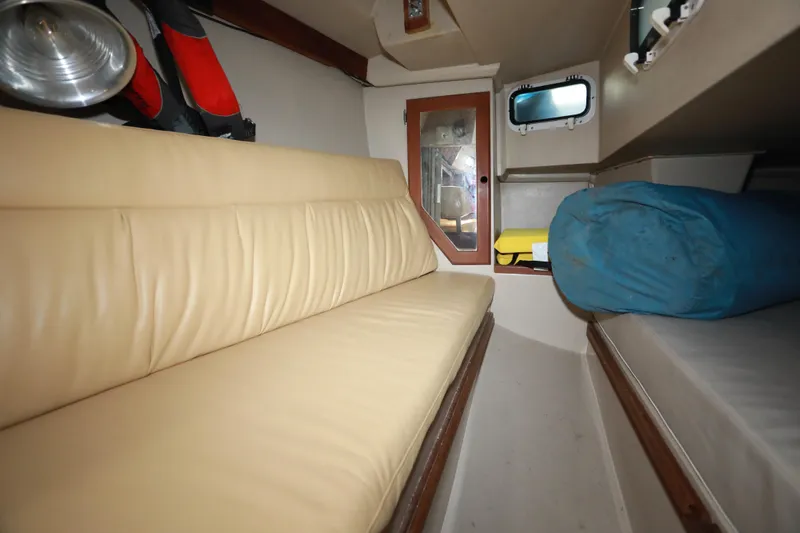 Slide: The Image of Interior of 1988 Catalina 36 sailboat with beige seating and storage space. - 35