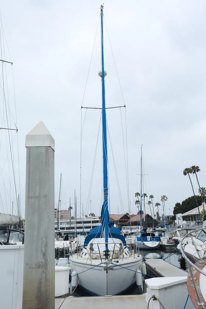 Slide: The Image of 1988 Catalina 36 sailboat docked in a marina, surrounded by other boats. - 7