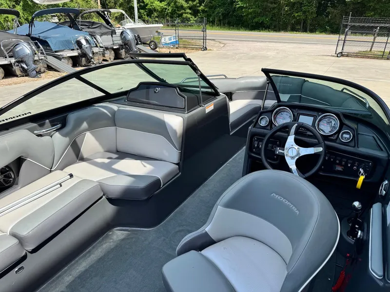 Slide: The Image of 2014 Moomba Mondo boat interior with gray seating and modern dashboard. - 11