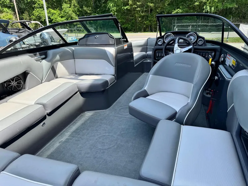 Slide: The Image of 2014 Moomba Mondo boat interior with gray seating and modern dashboard. - 16