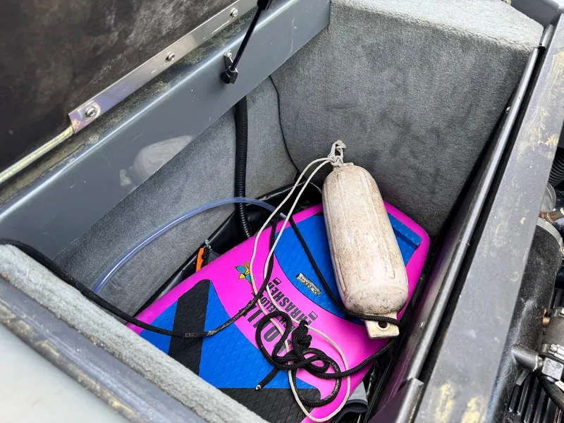 Slide: The Image of Storage compartment in a 2014 Moomba Mondo boat with wakeboard and fender. - 27