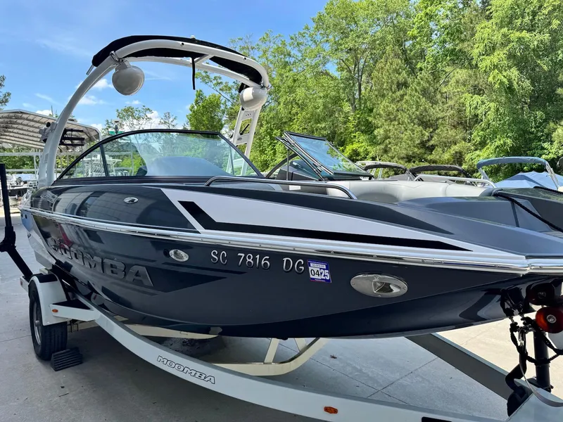 Slide: The Image of 2014 Moomba Mondo boat on trailer, sleek design, parked outdoors. - 7
