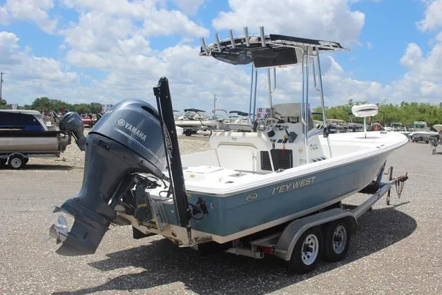 Slide: The Image of 2011 Key West 216 Bay Reef boat with Yamaha engine on trailer, parked outdoors. - 4
