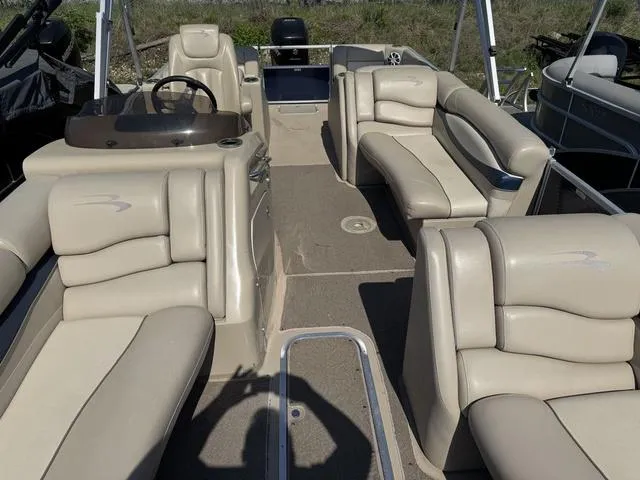 Slide: The Image of 2012 Bennington 2575 RCW pontoon boat interior with beige seating and steering console. - 10