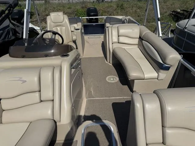 Slide: The Image of 2012 Bennington 2575 RCW pontoon boat interior with beige seating and steering console. - 11