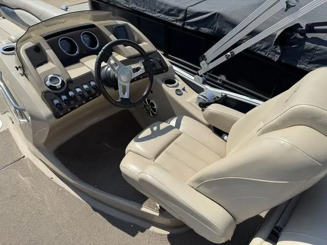Slide: The Image of 2012 Bennington 2575 RCW boat interior with beige captain's chair and control panel. - 13